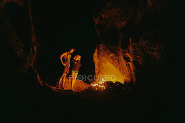 Giovane coppia di fronte al fuoco del campo di notte nel nord della California. — Foto stock