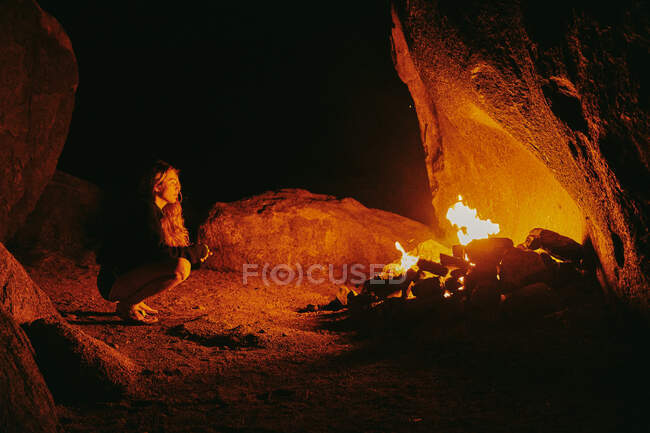 Молода жінка перед вогнем табору вночі в північній Каліфорнії . — стокове фото
