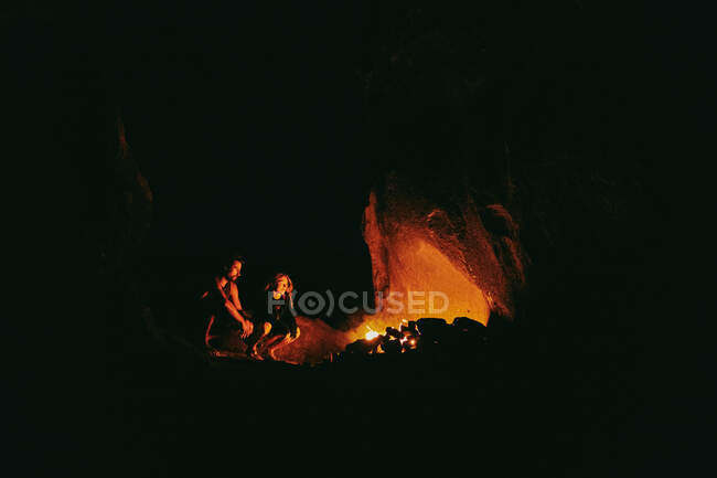 Jovem casal em frente ao acampamento de fogo à noite no norte da Califórnia. — Fotografia de Stock