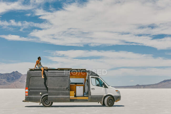 Young man on camper van roof — Stock Photo