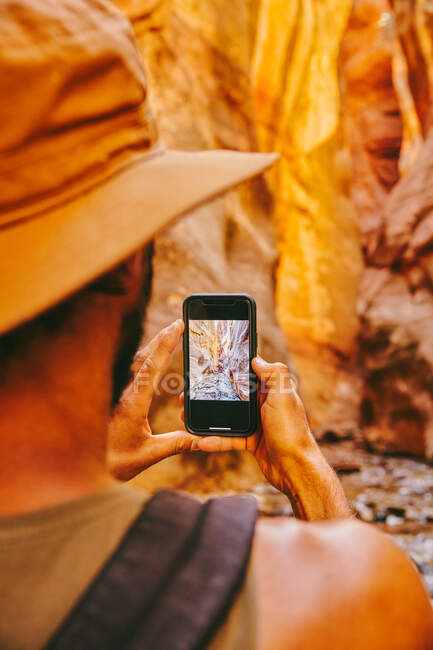Молодий чоловік у капелюсі фотографує каньйони слотів у водоспаді Канарра. — стокове фото