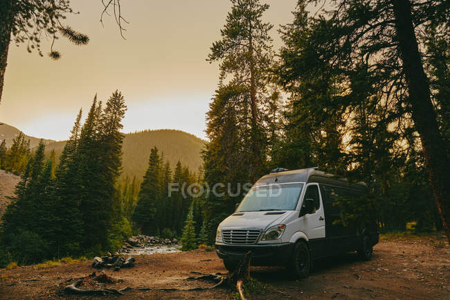 Camper van on river bank. road trip — Stock Photo