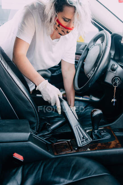Donna pulisce interni auto con aspirapolvere — Foto stock