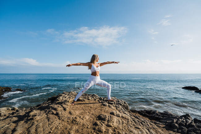 Красива жінка практикує йогу на пляжі — стокове фото