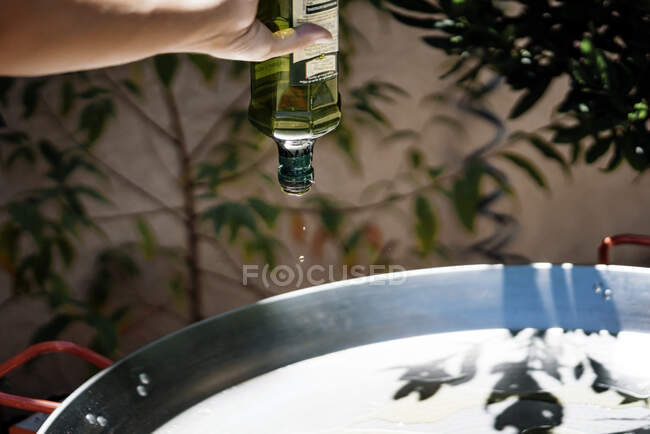 Frau bereitet ein spanisches Gericht mit Tintenfischgarnelen und Nudeln in einer Paella-Pfanne zu — Stockfoto
