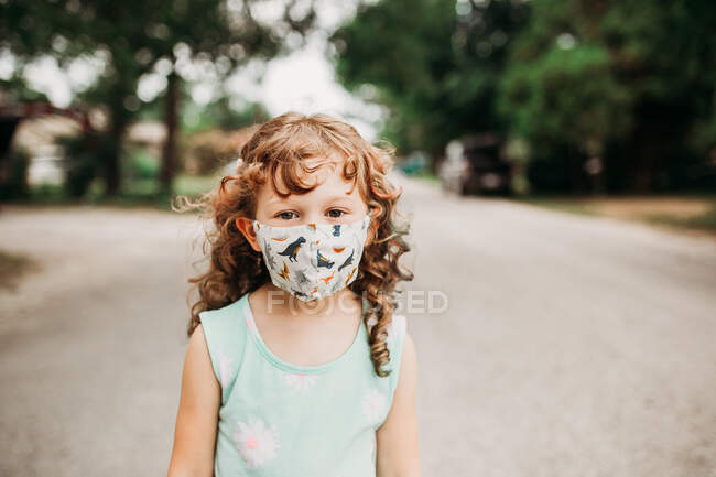 Mignonne petite fille portant masque facial — Photo de stock