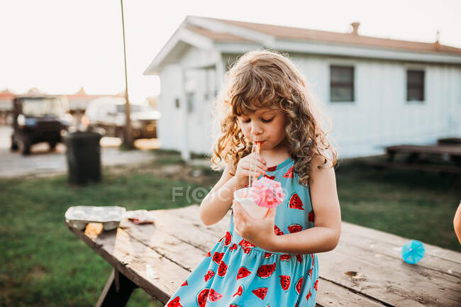Милая маленькая девочка пьет коктейль — стоковое фото