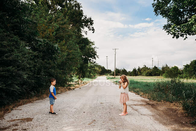 Junges Mädchen fotografiert Bruder mit Sofortkamera — Stockfoto