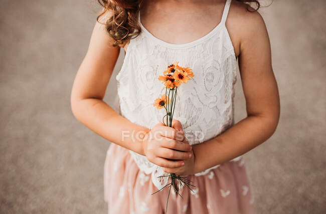 Cute little girl holding flowers — Stock Photo