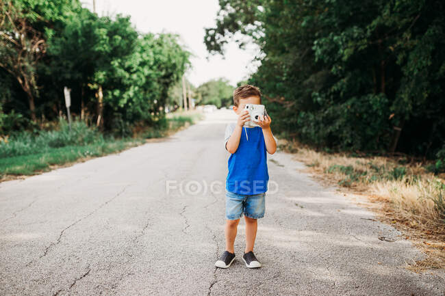 Симпатичный мальчик с фотоаппаратом в руках — стоковое фото