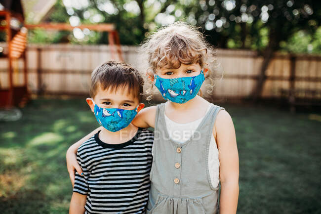 Netter Bruder und Schwester mit Mundschutz — Stockfoto