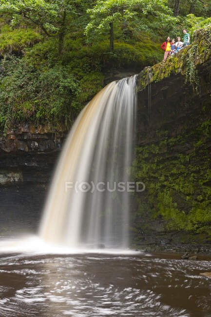 Familie auf dem Sgwd Gwladys Wasserfall in den Brecon Beacons — Stockfoto