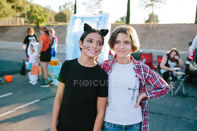 Joven adolescente niñas de pie juntos en un tronco de Halloween o tratar evento - foto de stock