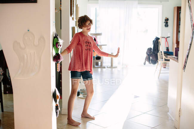 Barefoot teen girl stands inside her home and poses awkwardly — Stock Photo
