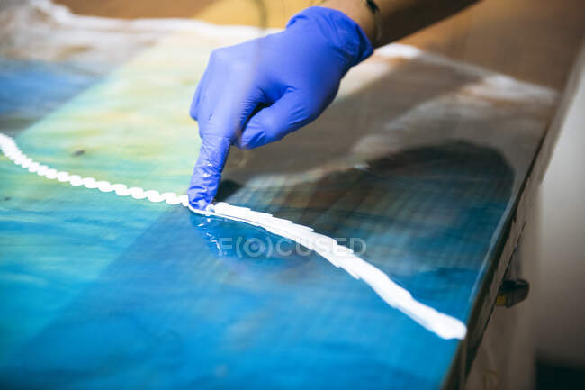 Female resin artist using hands to perfect artwork — Stock Photo