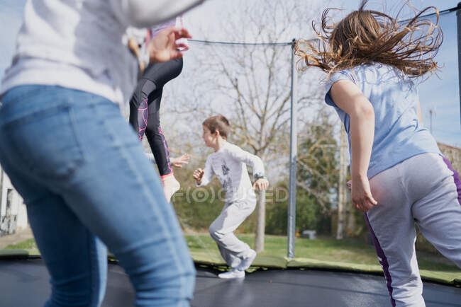 Діти стрибають на батуті в парку — стокове фото