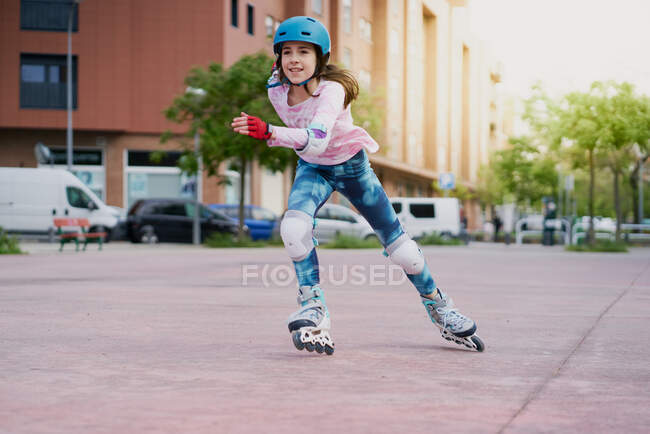 Girl on the street skates with inline skates and helmet — Stock Photo