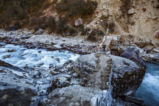 Sherpa-Träger überquert Brücke im nepalesischen Khumbu-Tal. — Stockfoto