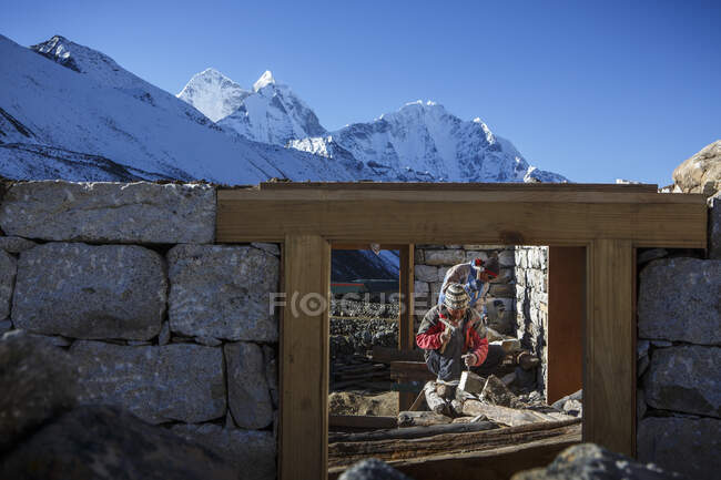 Trabajadores construyen una casa de huéspedes en el valle de Khumbu, Nepal, cerca de Ama Dablam. - foto de stock