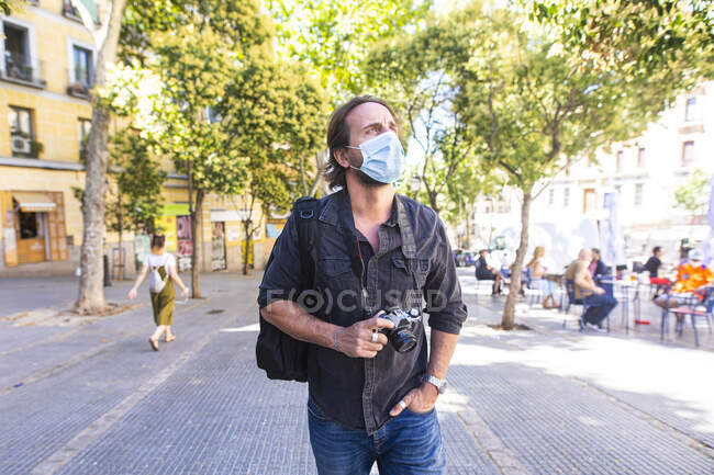 Turista en tiempos coronavirus visitando una ciudad - foto de stock