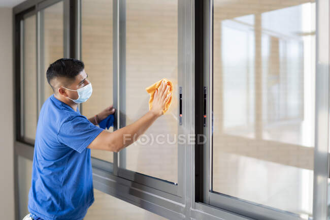 Cleaning staff disinfecting the windows to avoid covid19 — Stock Photo