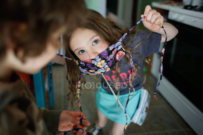 Menina e menino pedindo ajuda para colocar em suas máscaras — Fotografia de Stock