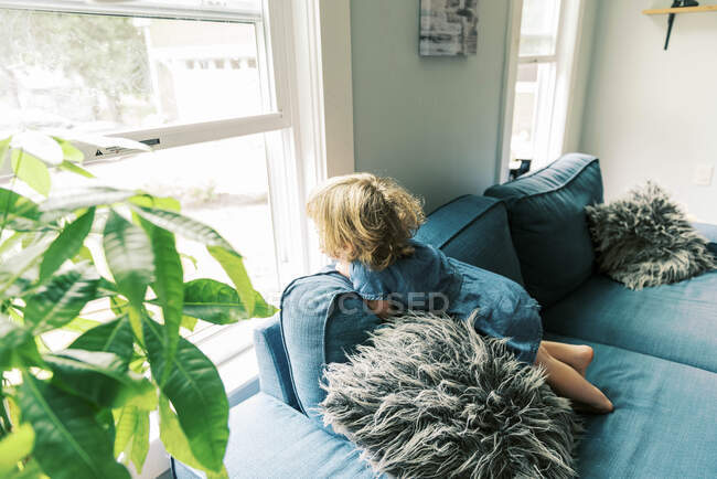 A little girl looking out of the window — Stock Photo