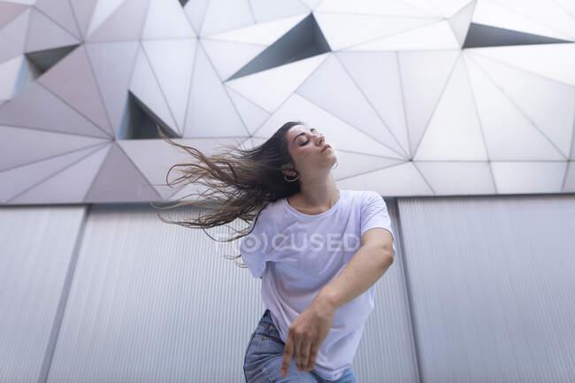 Young woman dancing with passion and energy in the street — Stock Photo