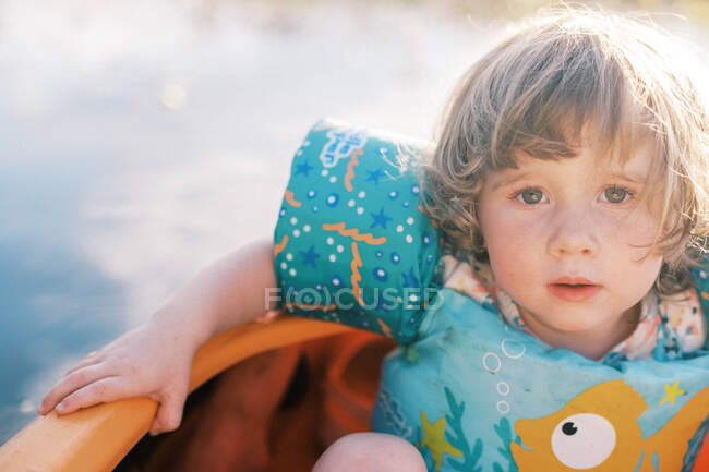 Дівчинка-малюк сидить перед каяком у жилеті — стокове фото