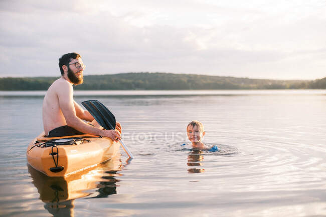 Um pai e um filho desfrutando de um dia quente de verão no lago juntos — Fotografia de Stock