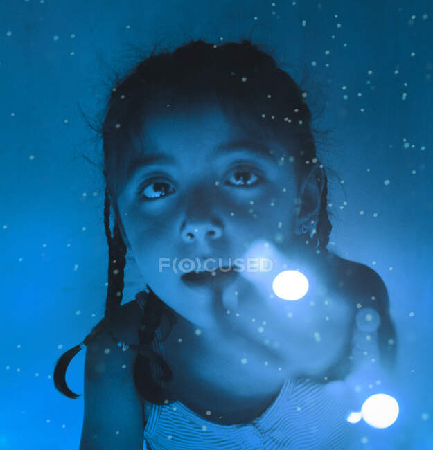 Fille avec de la lumière dans les mains dans un environnement bleu — Photo de stock