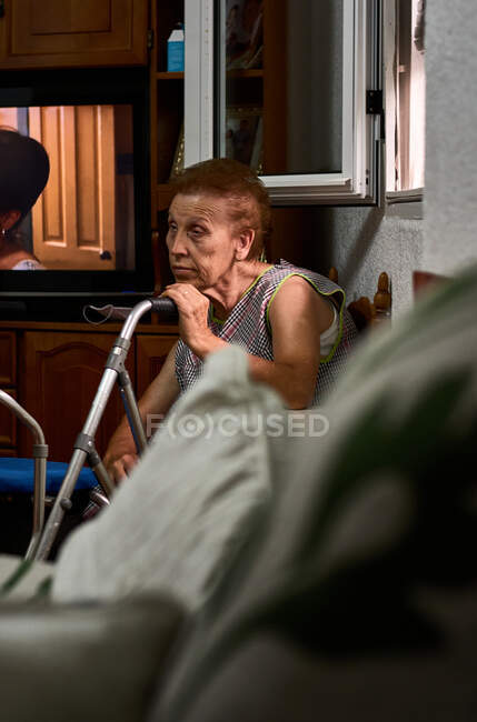 Una vecchia signora che tiene il suo deambulatore a casa — Foto stock