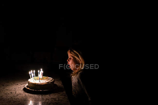 Kleines Mädchen bläst Geburtstagskuchenkerzen aus — Stockfoto