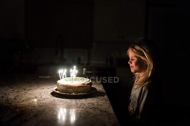 Маленька дівчинка робить бажання перш ніж вибухнути свічки на день народження — стокове фото