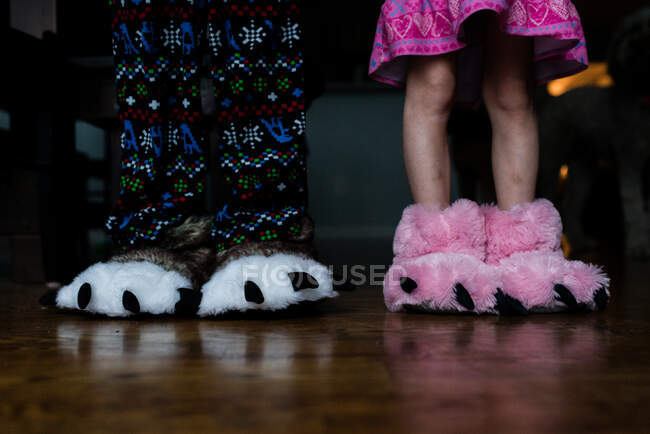 Kids feet in animal feet slippers — Stock Photo