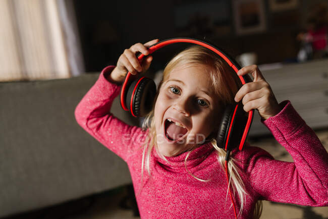 Kleines Mädchen singt mit Kopfhörern — Stockfoto