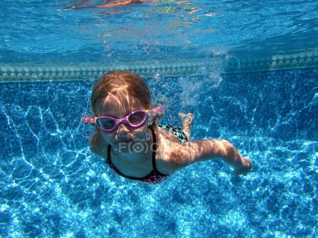 Девушка плавает под водой в очках — стоковое фото