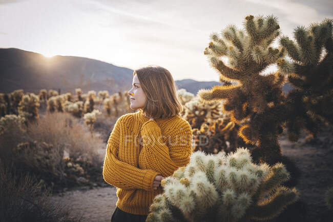Mujer está de pie cerca de un cactus en el desierto de California - foto de stock