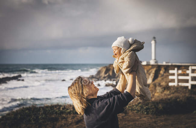 Joven madre jugando con bebé al aire libre - foto de stock