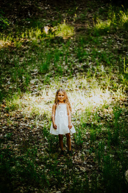 Retrato vertical de menina de pé na colina na floresta. — Fotografia de Stock