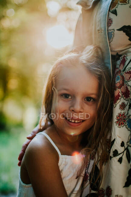 Retrato vertical de menina abraçando a mãe e sorrindo — Fotografia de Stock