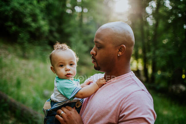 Father holding and looking at infant son — Stock Photo