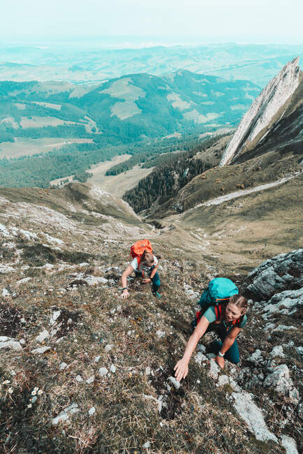 Hikers with backpacks climbing mountain - foto de stock