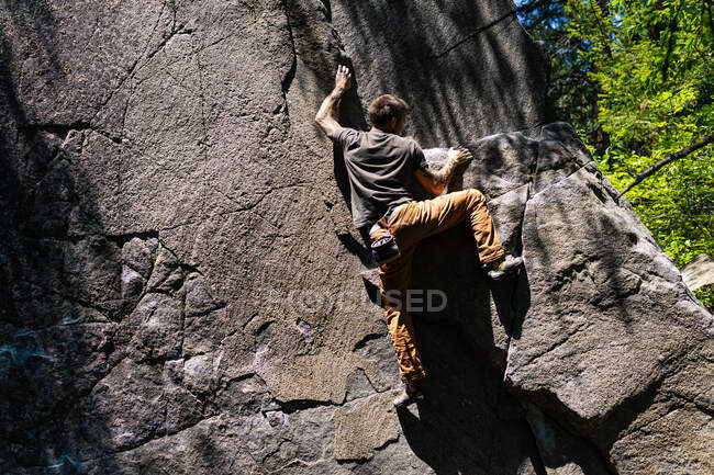 Climber is getting to the top of the granite boulder in Washington — Stock Photo