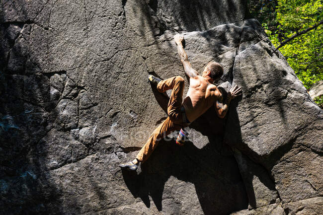 Climber using heel hook to get to the top of the boulder — Stock Photo