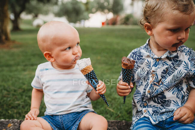 Jeune bambin blanc et bébé manger de la crème glacée en été — Photo de stock