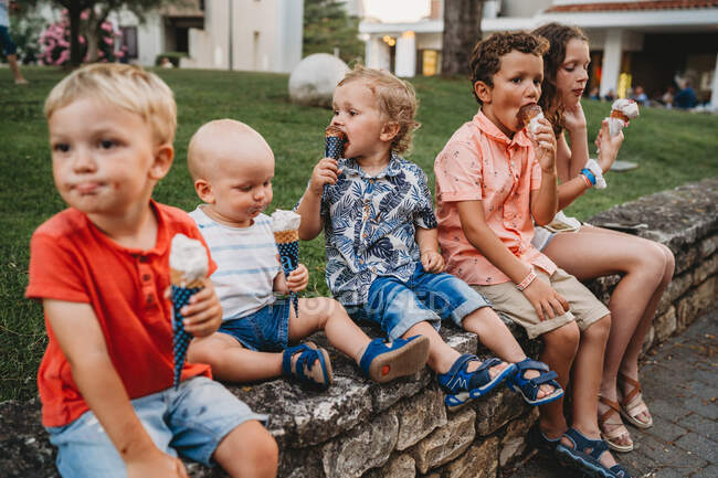 Meninos e meninas comendo sorvete juntos durante as férias de verão — Fotografia de Stock