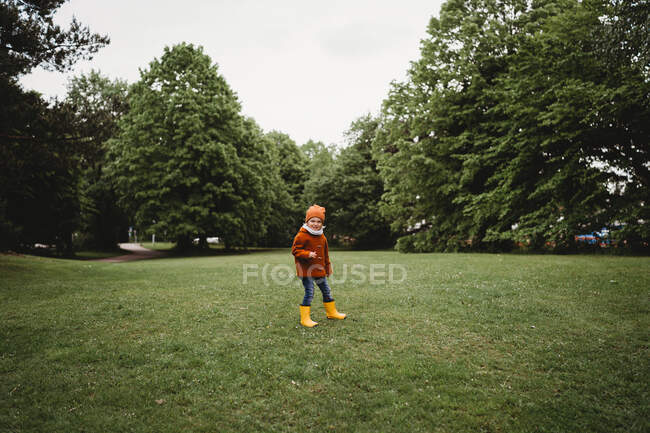 Jeune enfant mâle marchant dans le parc par une journée nuageuse — Photo de stock