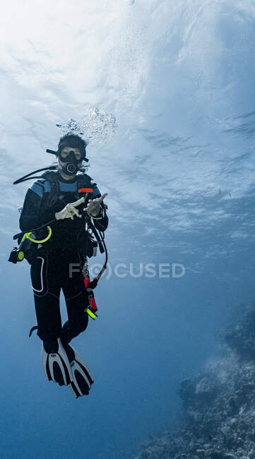Mergulhador perguntando amigo quanto ar ele deixou usando sinal de mão — Fotografia de Stock