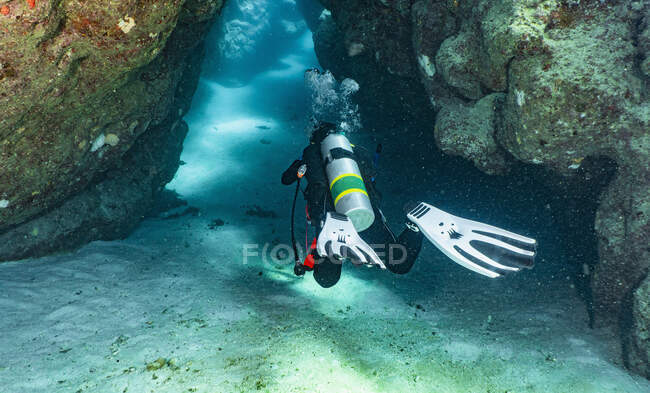Subacqueo esplorare grotta presso la grande barriera corallina — Foto stock